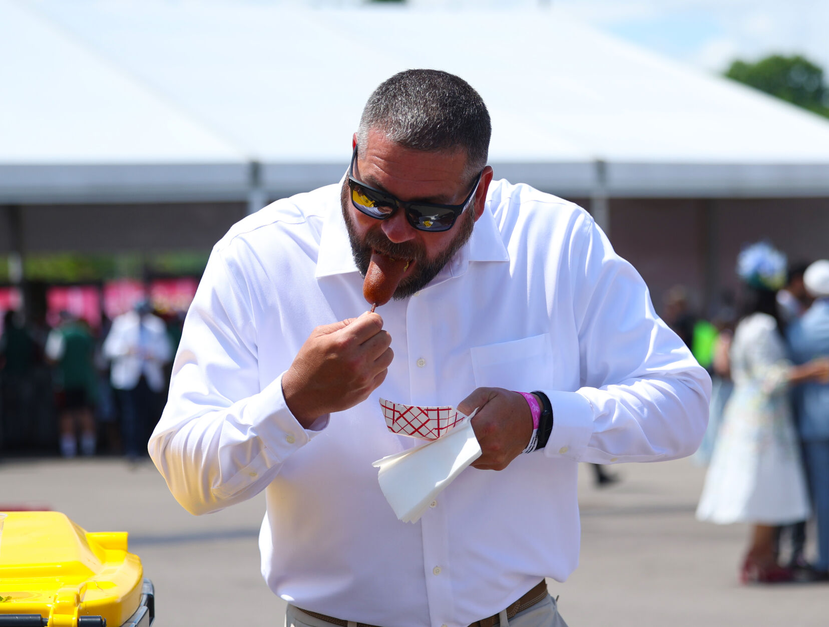 Man eats a corndog at Churchill Downs.JPG